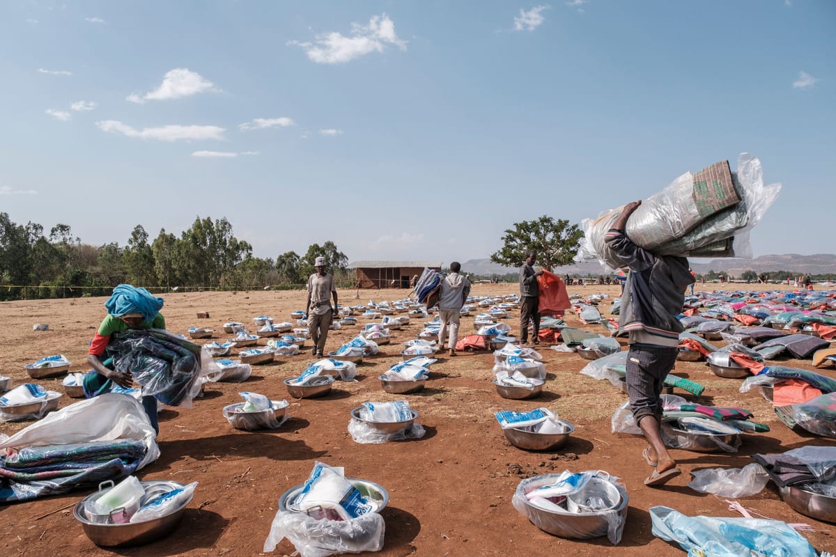 People organize piles of items during an items distribution by an international nongovernmental organization for internally displace people fleeing violence, in Chagni, Ethiopia, on January 28, 2021. 