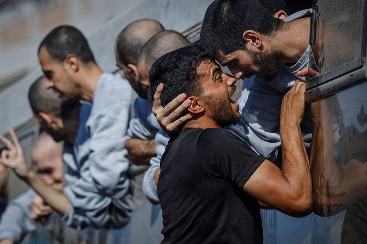 A man embraces another man from the window of a vehicle.