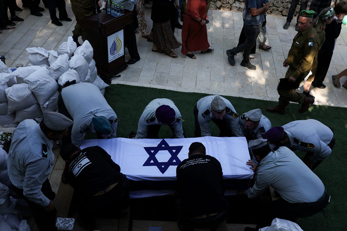 People carry a coffin draped in an Israeli flag.