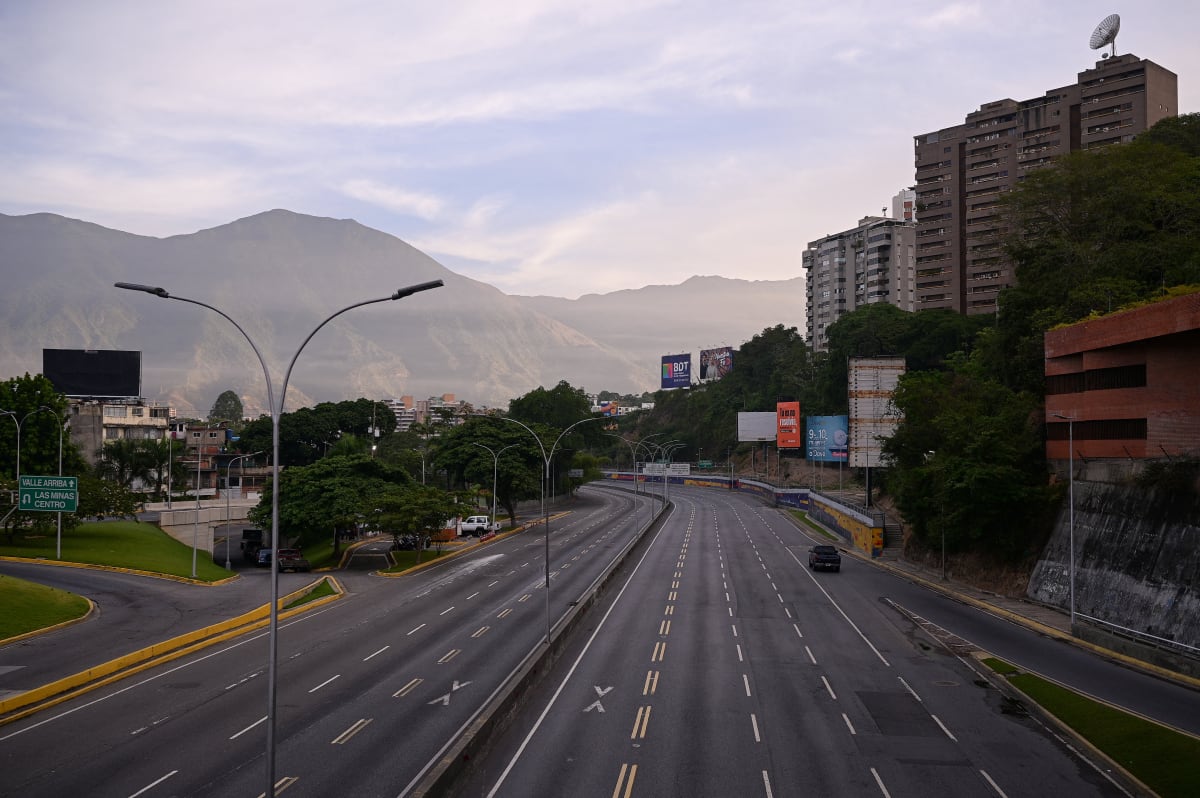 An empty highway with mountains in the background.