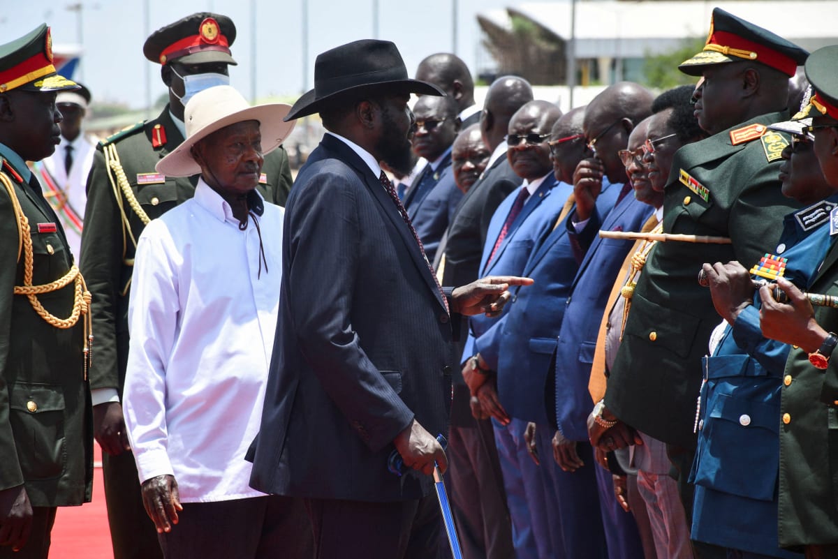 A row of men in suits face a group of men.