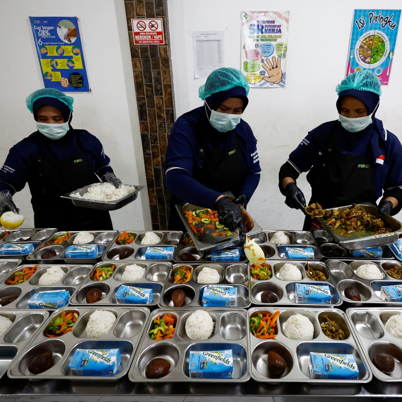 Workers prepare meals to be distributed free for students, during the free nutritious meals program trial, at a pilot kitchen in Sukabumi, West Java province, Indonesia, September 25, 2024.