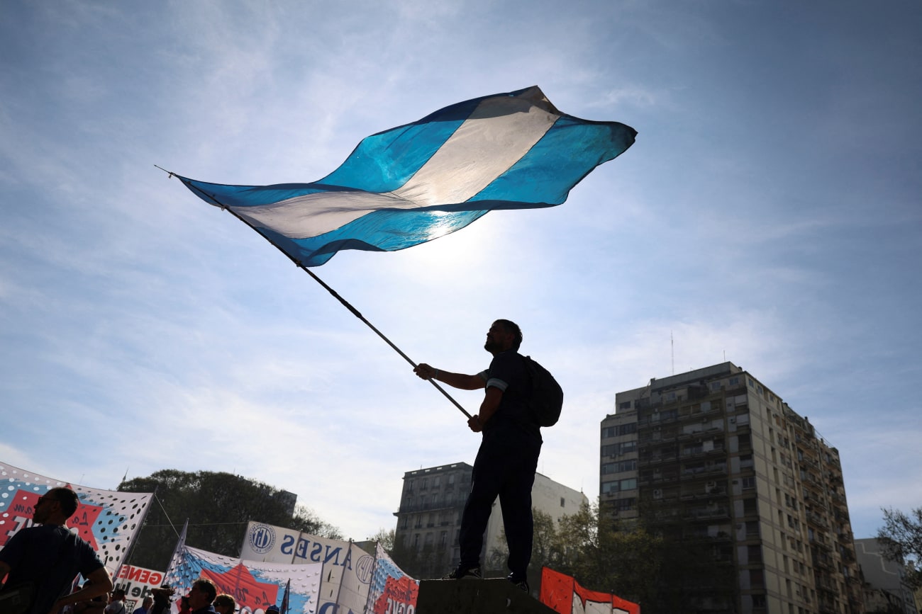 A demonstrator waves the Argentinian flag while taking part in a march to defend public universities, after Argentina's President Javier Milei vetoed laws to boost funding for pediatric hospitals and public universities, citing efforts to rein in public spending, in Buenos Aires, Argentina, on September 17, 2025.