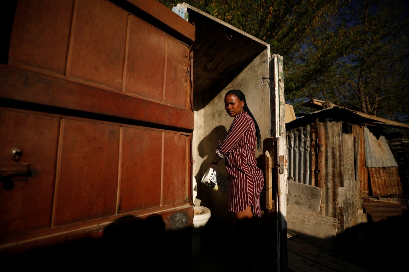 A woman pours a pot of recycled grey water into a toilet in drought-stricken Graaff-Reinet, South Africa, on November 16, 2019.