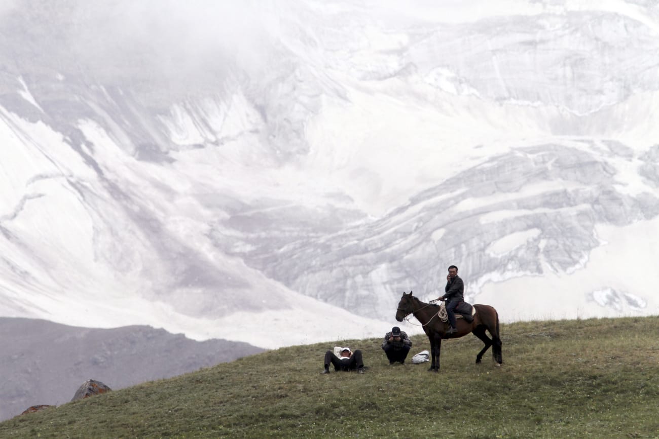 People gather before the Kyrgyz national horse games and festival, near the Tulpar-Kul lake, in the Chon Alai mountain range, in the Osh region of Kyrgyzstan, on July 25, 2015.