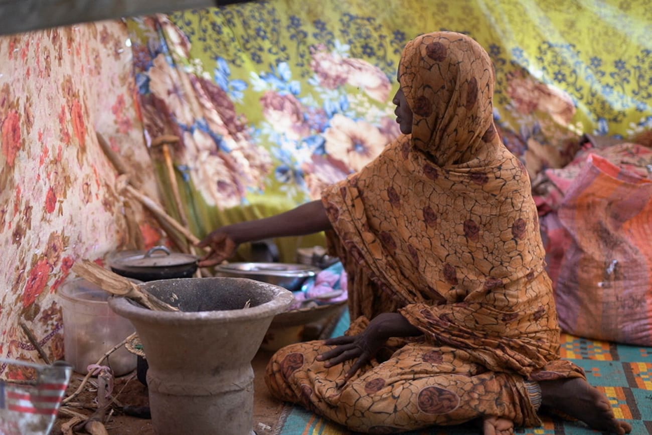 A Sudanese displaced woman who was held by the paramilitary Rapid Support Forces (RSF), cooks food at a camp for displaced people who fled from al-Fashir to Tawila, North Darfur, Sudan, on November 15, 2025.