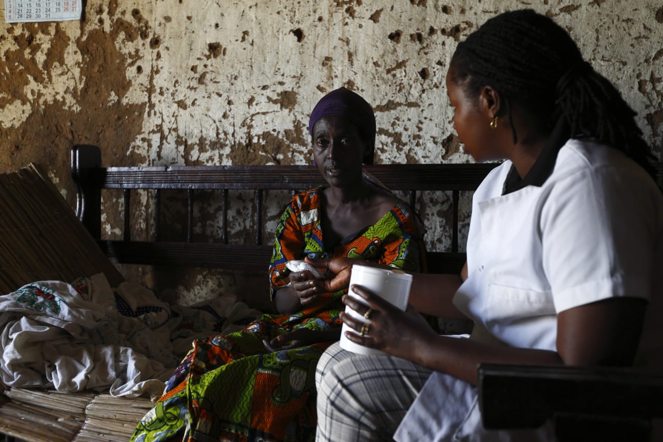 A Service Yezu Mwiza nurse hands medication to an HIV patient, who is also suffering from malaria, at her home, in Gatumba, Burundi, on April 19, 2013.