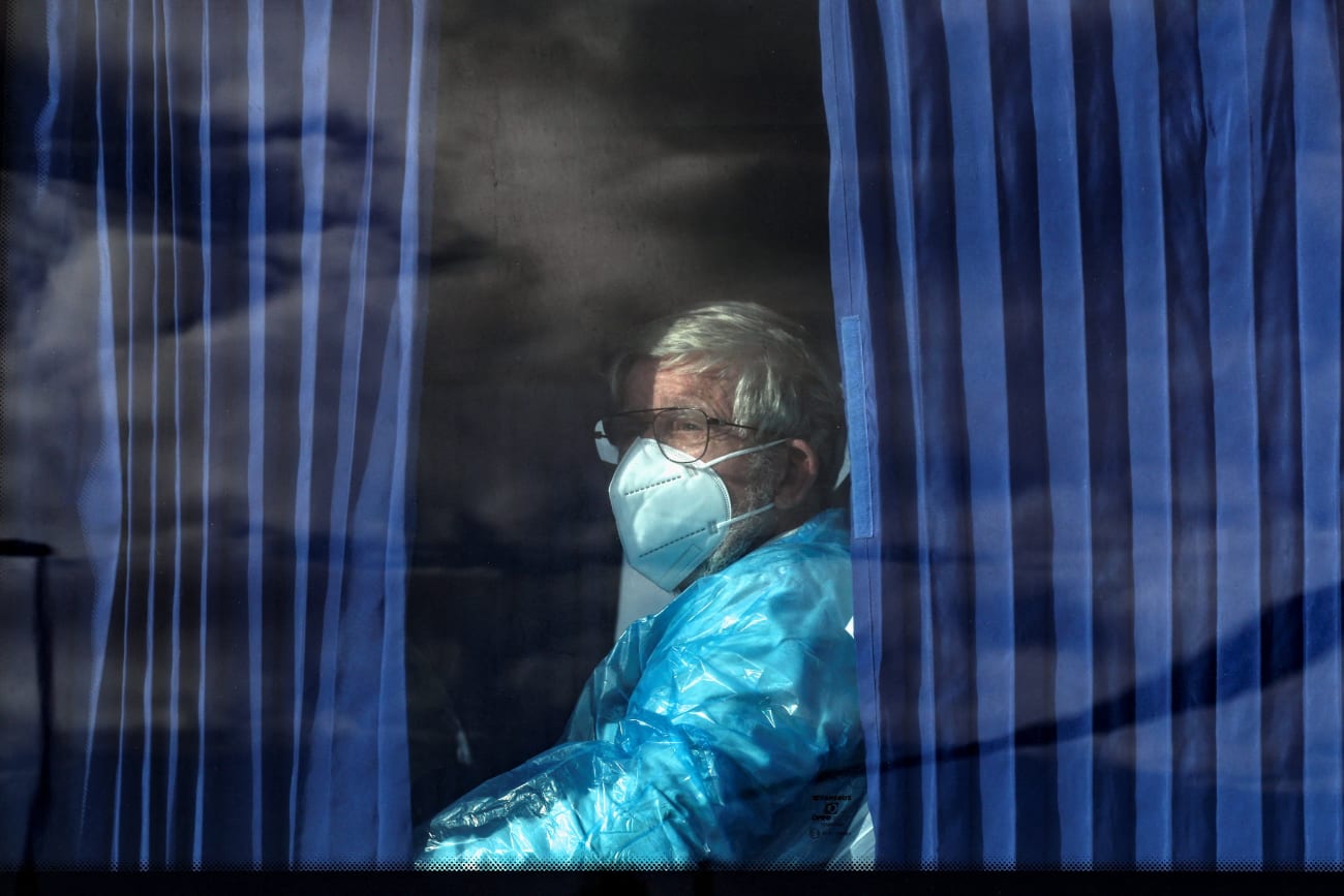 A passenger of the cruise ship MV Hondius, affected by a hantavirus outbreak, looks on from inside a bus as it leaves the port of Granadilla de Abona, in Tenerife, Spain, on May 11, 2026.