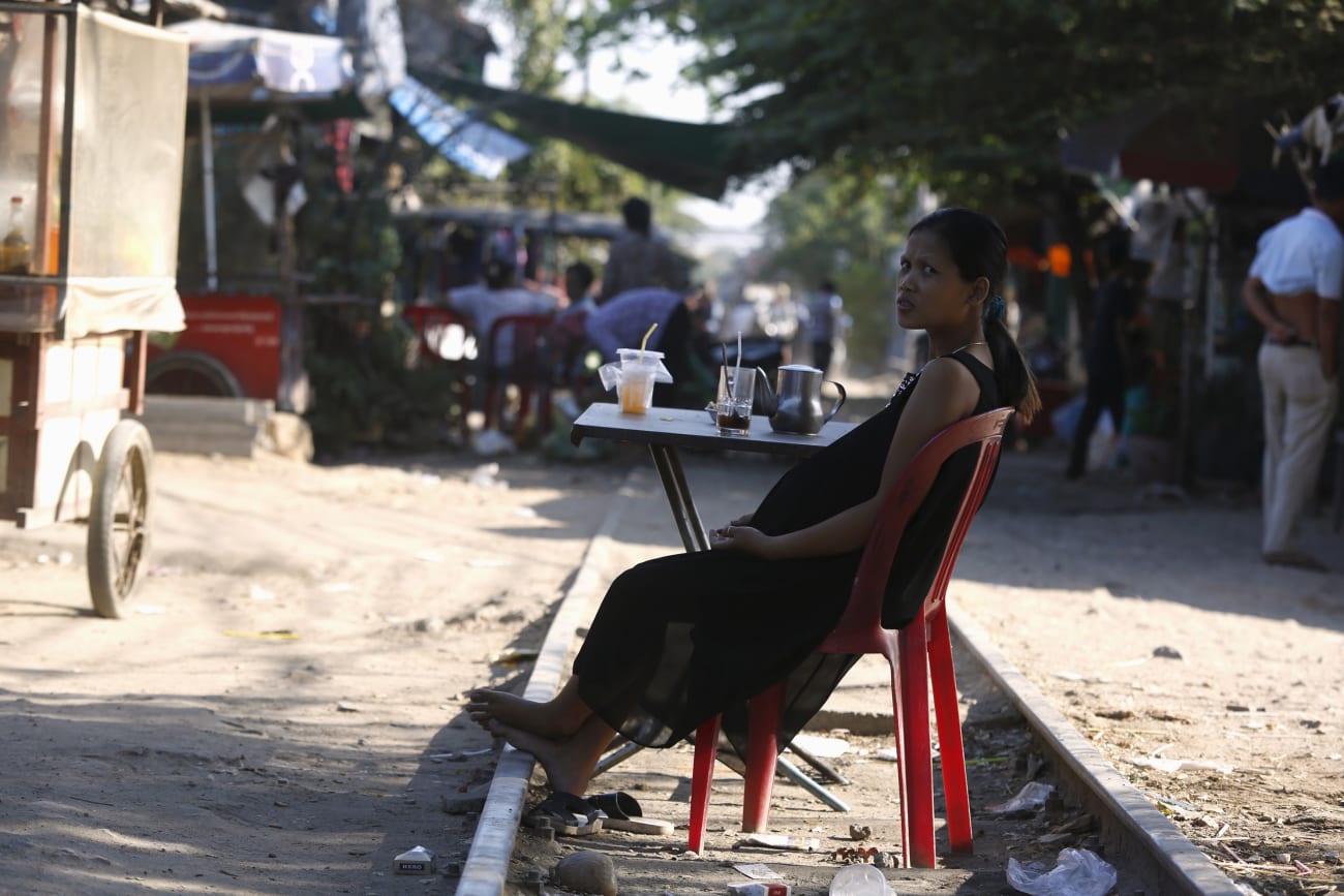 A pregnant woman rests on the railway track in front of her home, in Phnom Penh, Cambodia, on February 4, 2016.