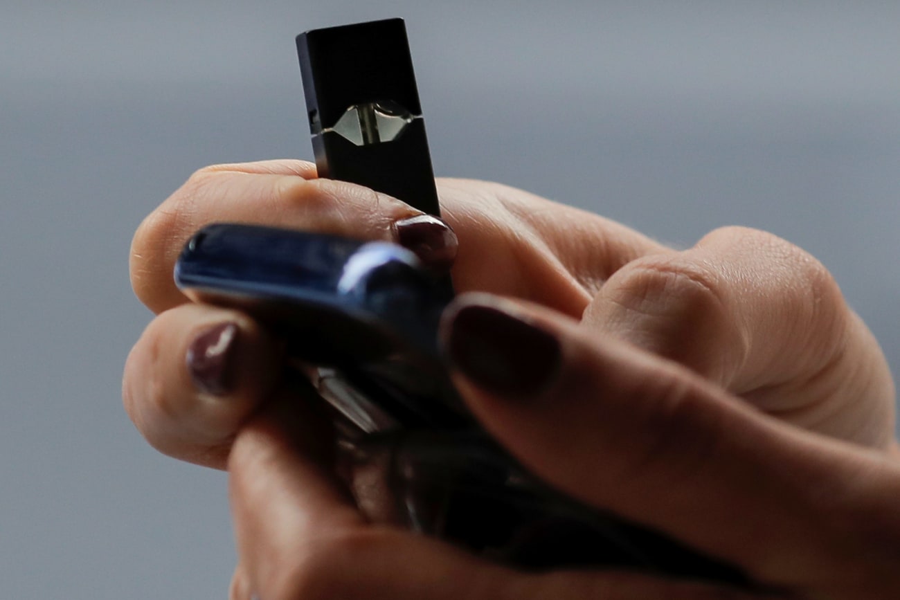 A woman holds a Juul e-cigarette while walking, in New York, on September 27, 2018.