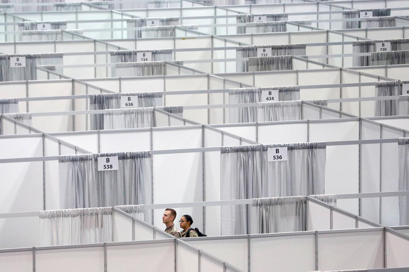 The photo shows the heads of two soldiers popping up over a sea of curtain-like separators.