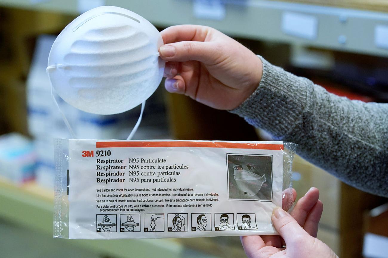 The image shows a pair of hands holding up the two masks in comparison.