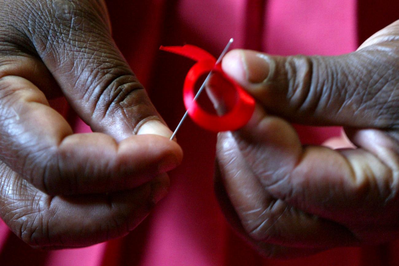 Picture shows a woman's hands delicately folding a small ribbon.