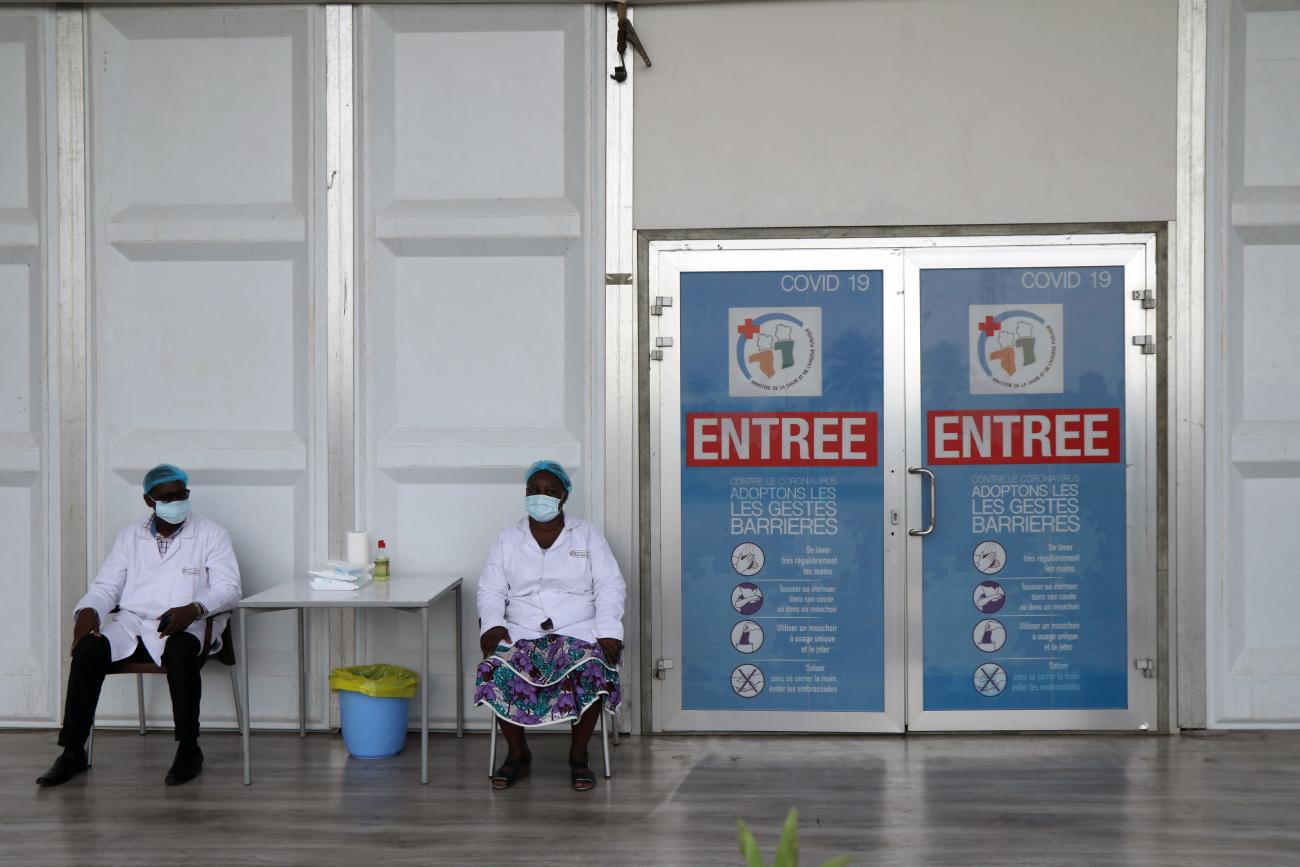 Members of the medical staff sit as they wait for people at the first reception center built to hold COVID-19 screening tests, in Abidjan, Ivory Coast, on April 15, 2020.