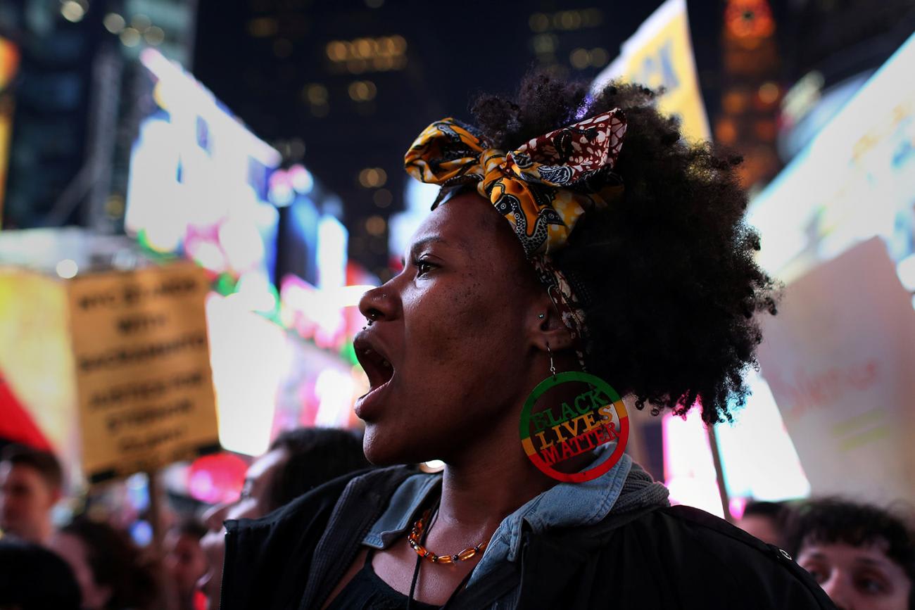 The photo shows the woman shouting as she marches amid protest signs, This is a striking photo.