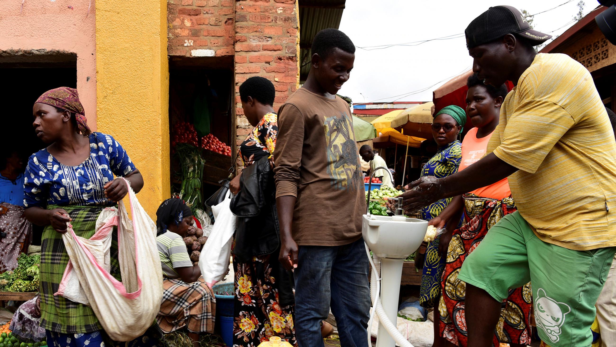 The picture shows a crowded scene with a man washing his hands