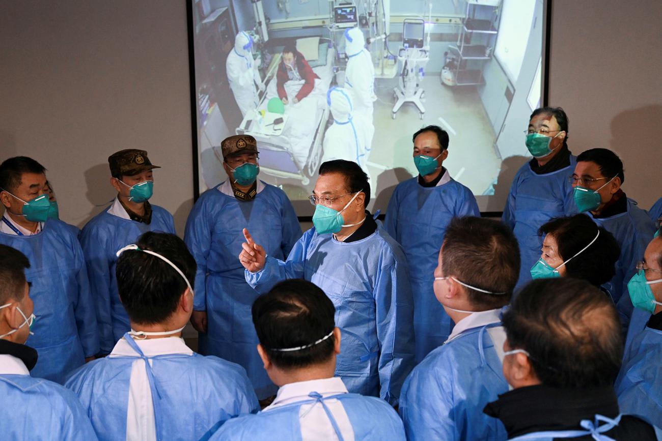 Picture shows the politician wearing protective gear talking to a room full of workers in the same gear.