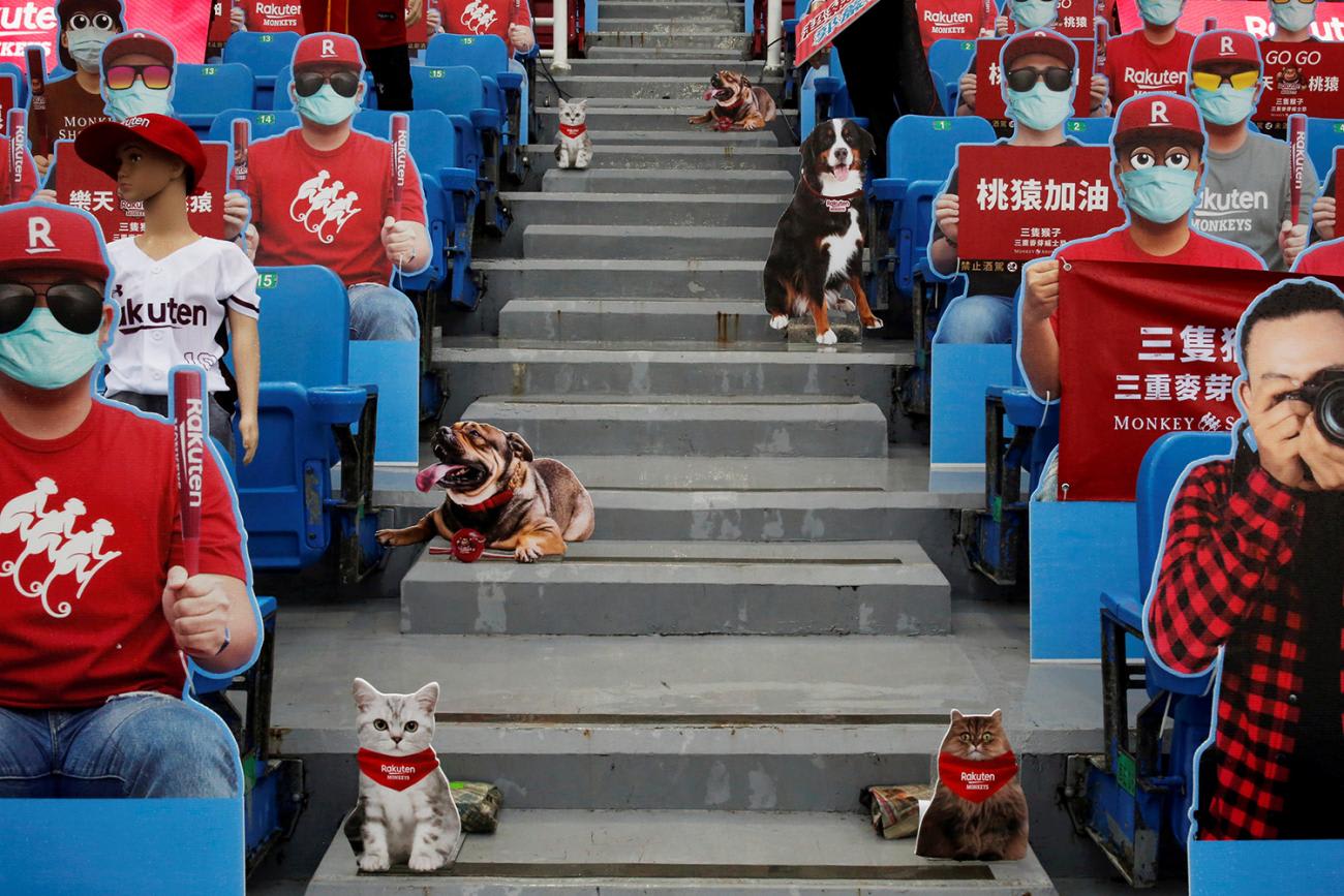 This is a very strange photo showing a section of seats at a sports venue filled with mannequins, cardboard cutouts and all manner of fake people.