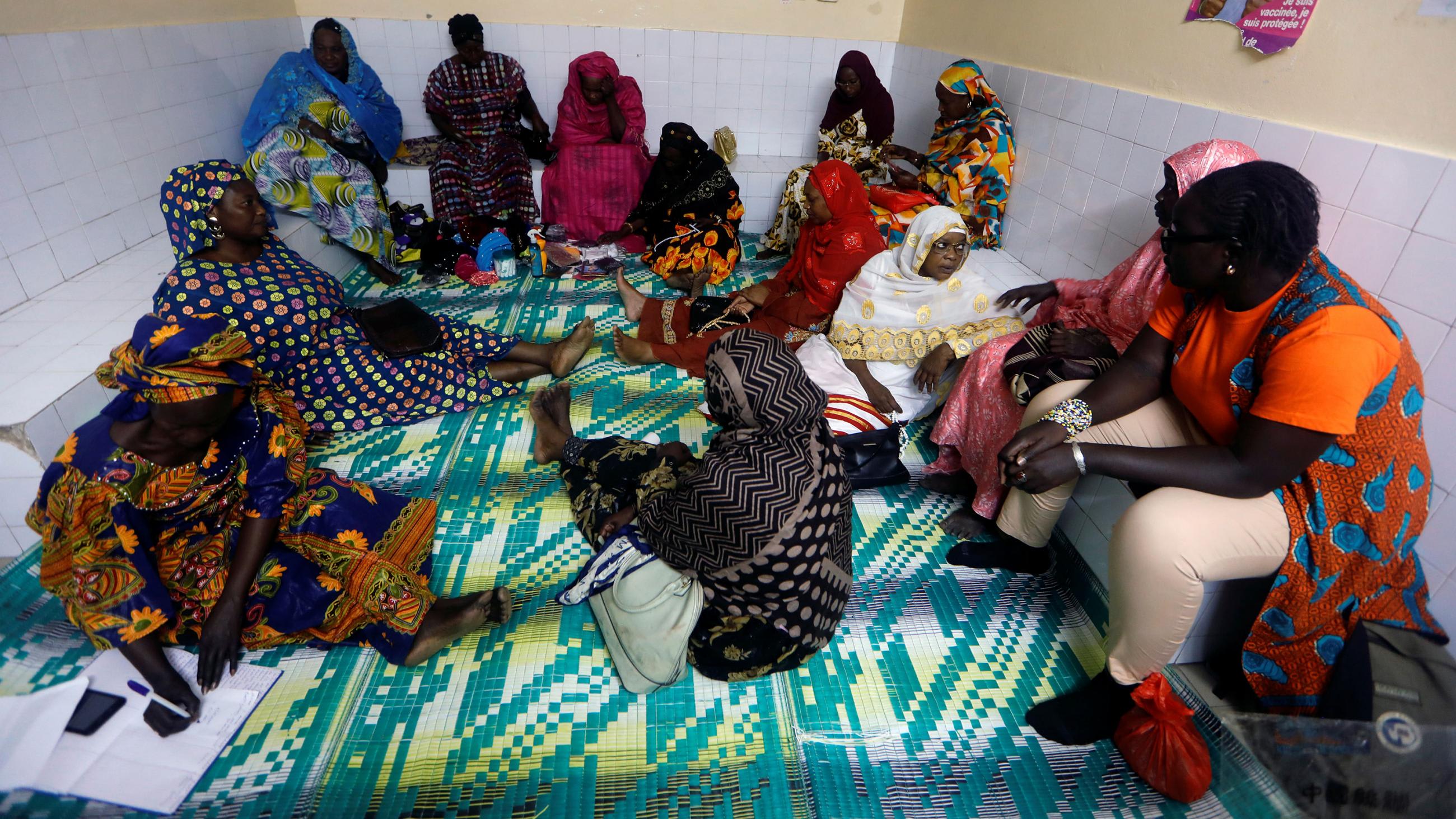 Picture shows a number of women sitting around a room adorned with posters.