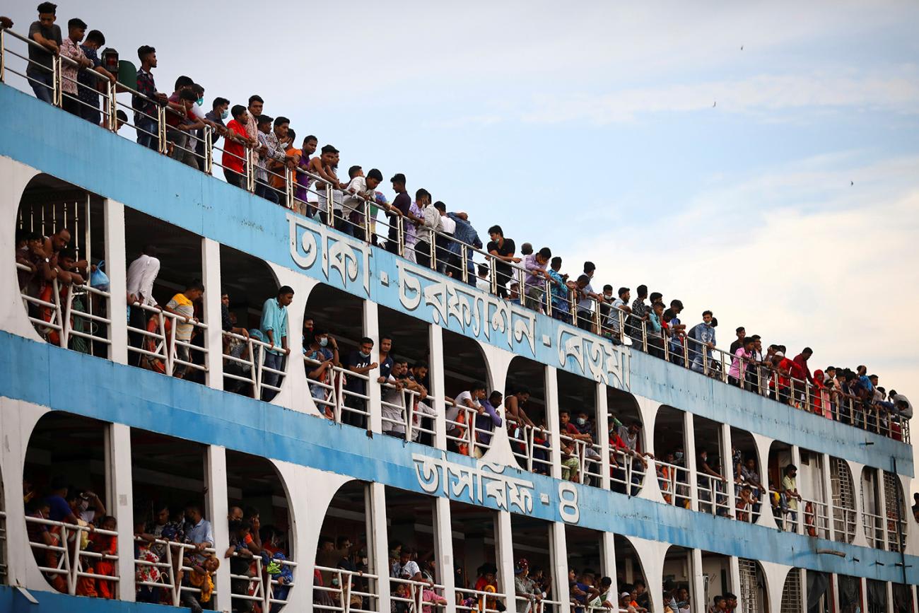The photo shows the ferry from the side with all balconies jammed with people, most not wearing masks.