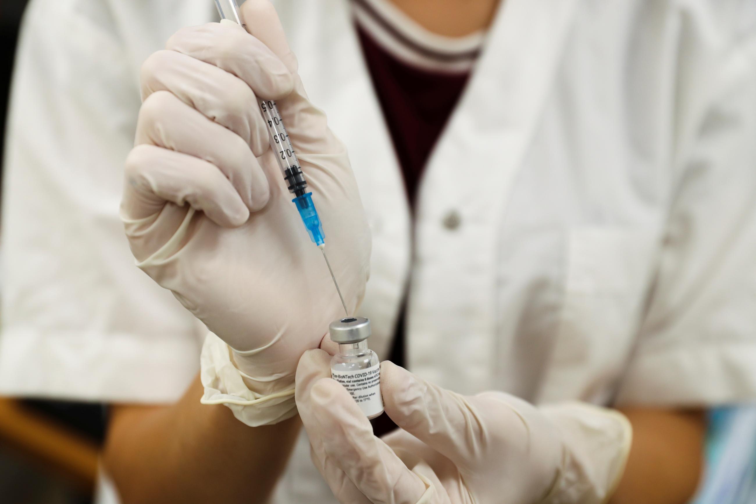 A medical worker prepares to administer a third dose of a COVID-19 vaccine at a Clalit healthcare maintenance organization in Jerusalem on August 1, 2021.