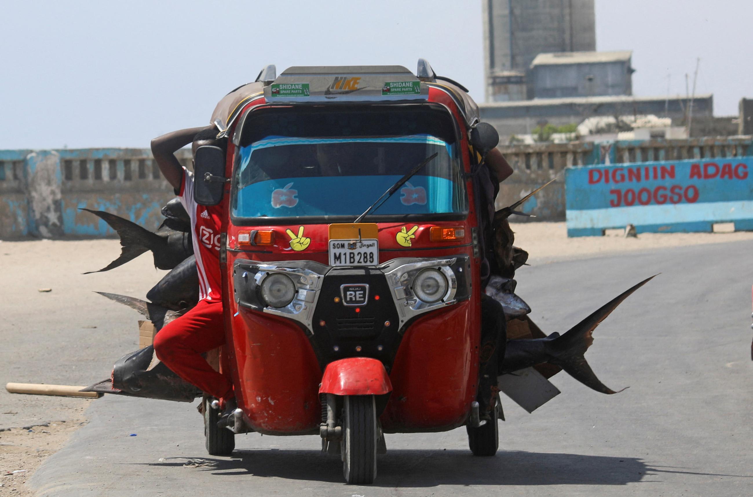 A red rickshaw taxi is loaded with various fish as it drives away from the beach in Hamarweyne district of Mogadishu, Somalia December 2, 2022.