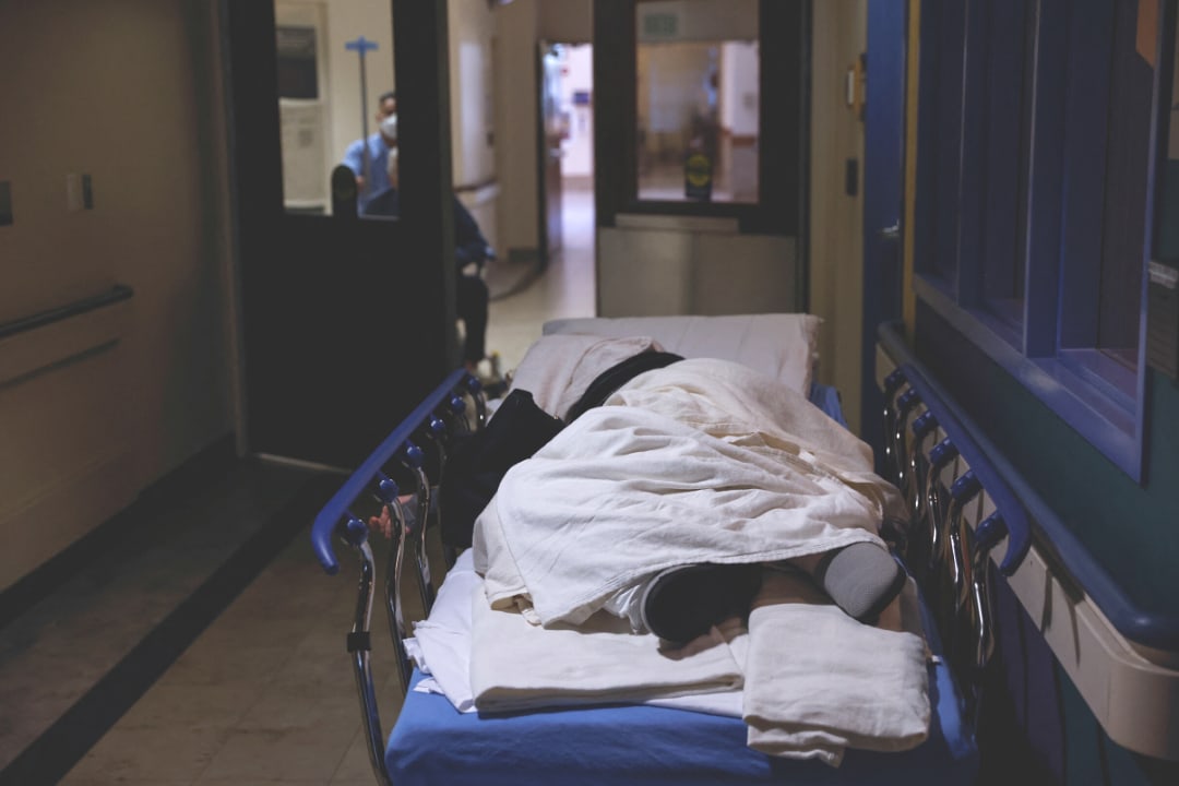 A patient rests on a gurney, waiting to be seen in the emergency room waiting area at Providence Mission Hospital in Mission Viejo, California, on January 27, 2022.