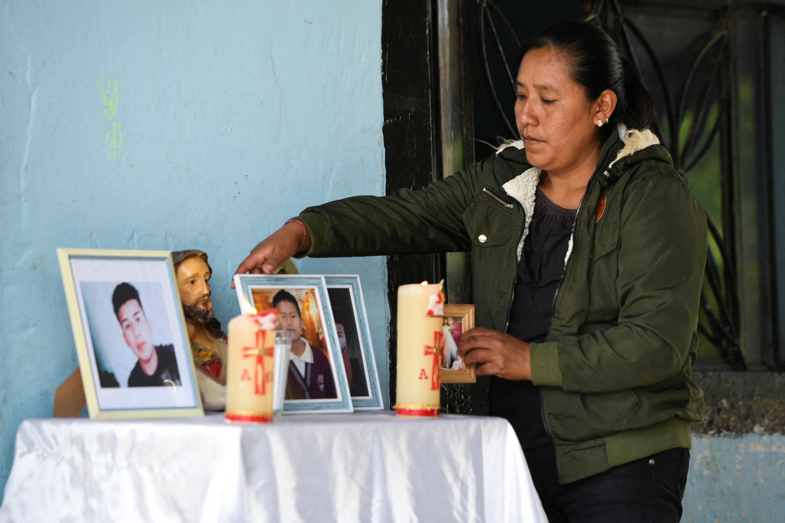 Yolanda Olivares, arranges pictures of her sons Jair, 19, Yovani, 16, and nephew Misael Olivares, 16, who died in a truck while migrating to the U.S.