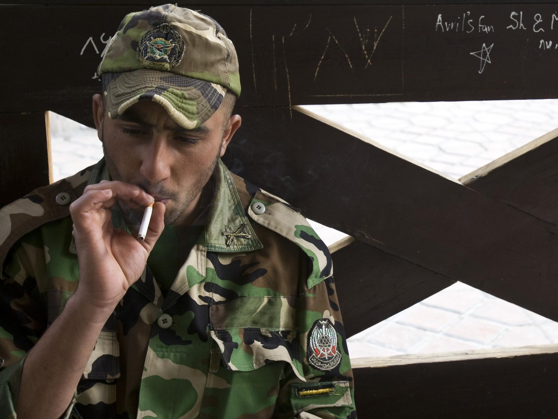 A member of the Iranian army smokes as he rests at a park in central Tehran, April 9, 2009.