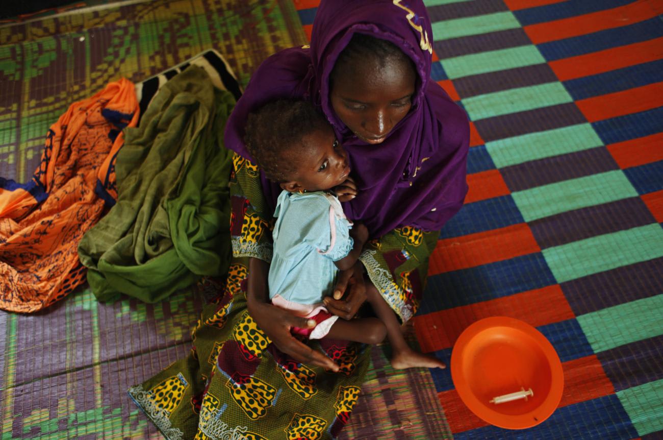 A mother, recovering from malnutrition, holds her child at a nutrition center in the Guidimakha region, Mauritania on June 3, 2012.
