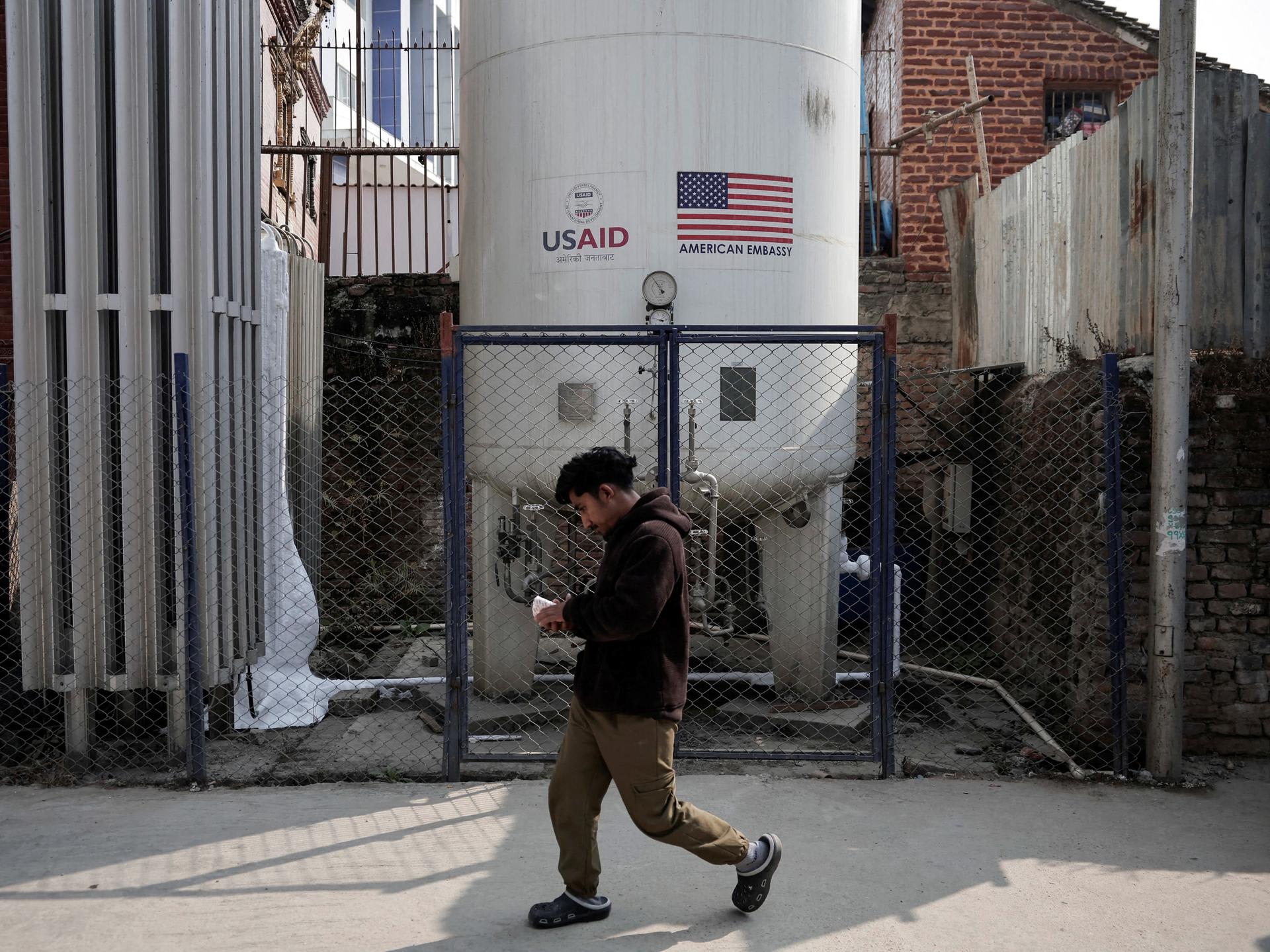 A man walks past the liquid oxygen storage tank installed at Bir Hospital by the United States Agency for International Development, in Kathmandu, Nepal, on February 9, 2025.