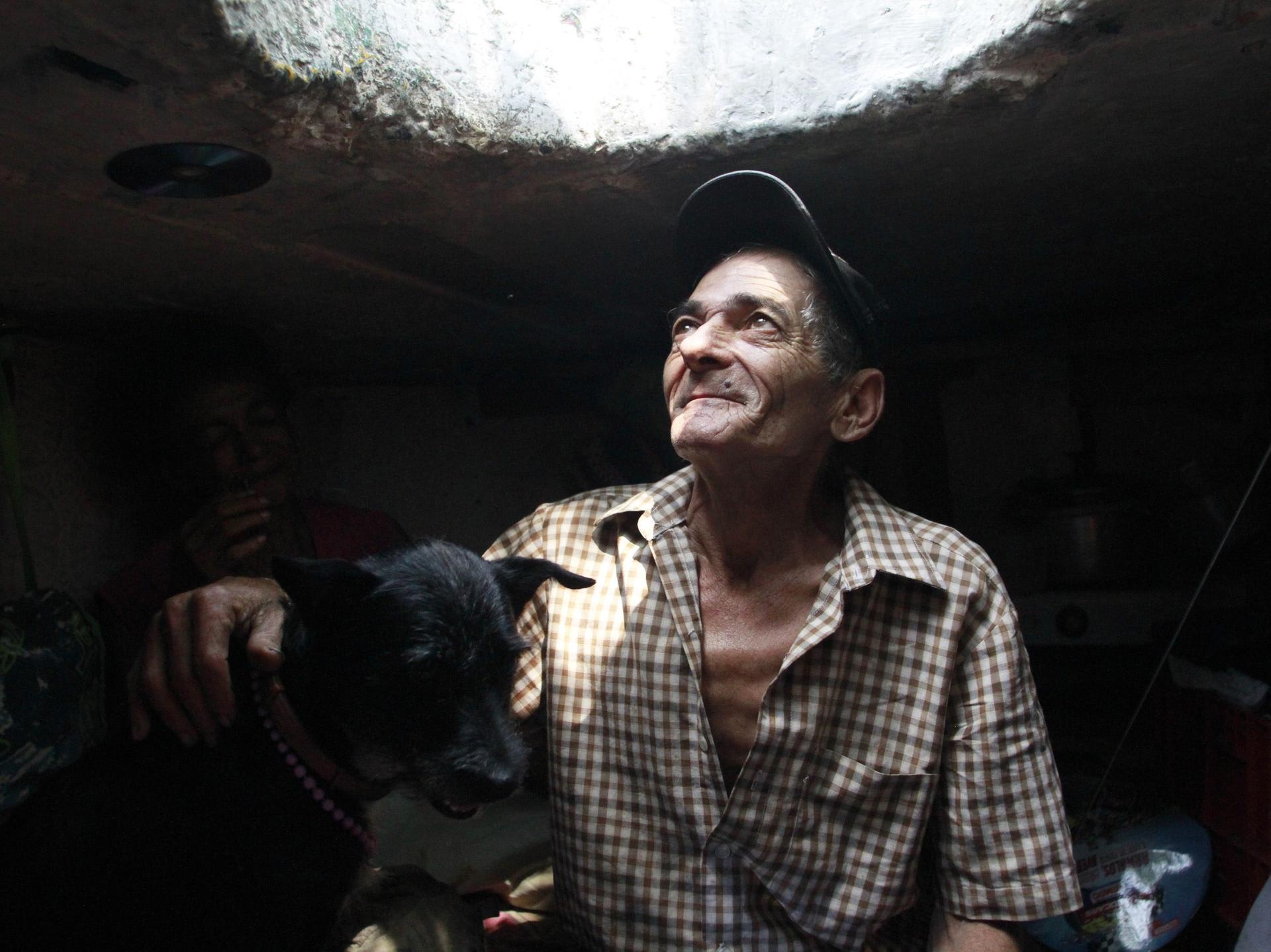 Miguel Restrepo, 62, a former drug addict, looks up from his sewer home in Medellin, Colombia, on December 4, 2012.