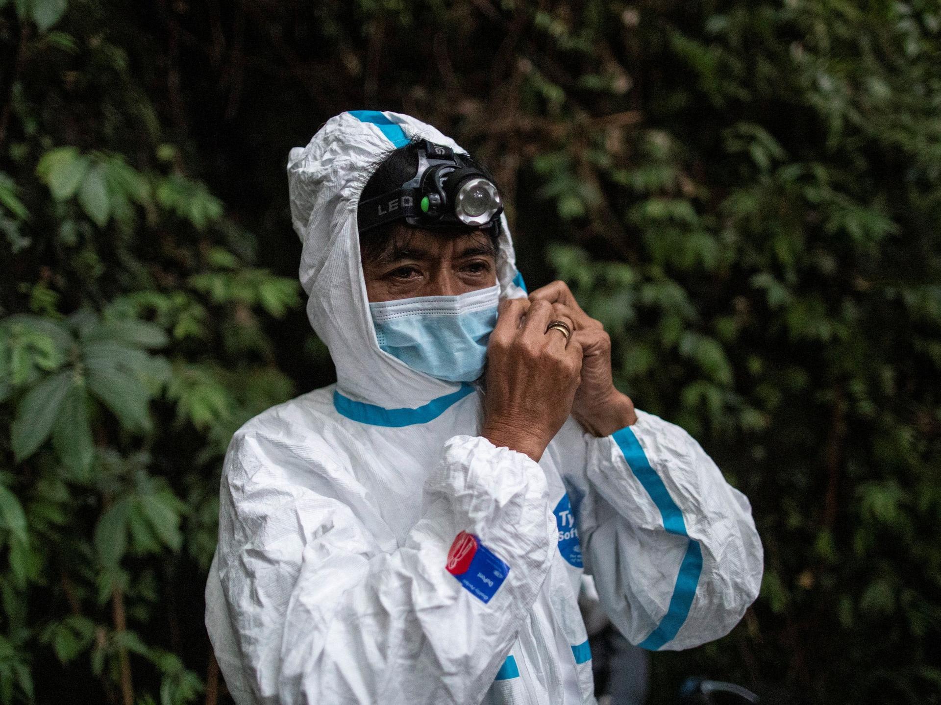Edison Cosico, an administrative aide at the UPLB Museum of Natural History, secures his hazmat suit, in Los Banos, Laguna province, Philippines, on February 18, 2021