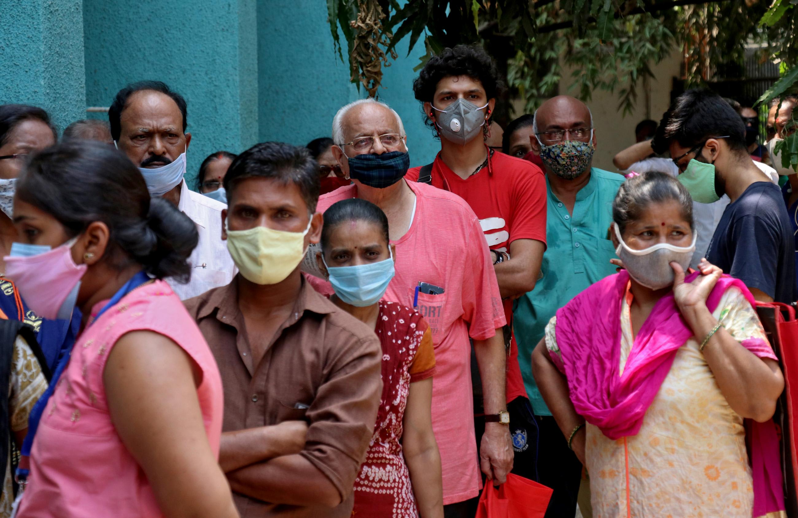 People wearing protective face masks wait to receive a vaccine against the coronavirus disease at a vaccination center in Mumbai, India on April 28, 2021.