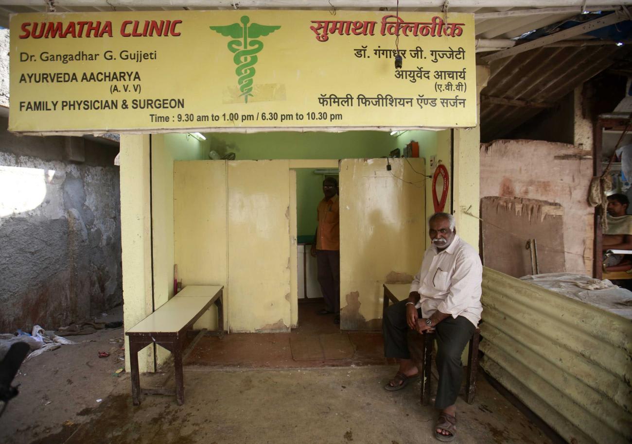 A patient waits outside a doctor's clinic in a residential area.
