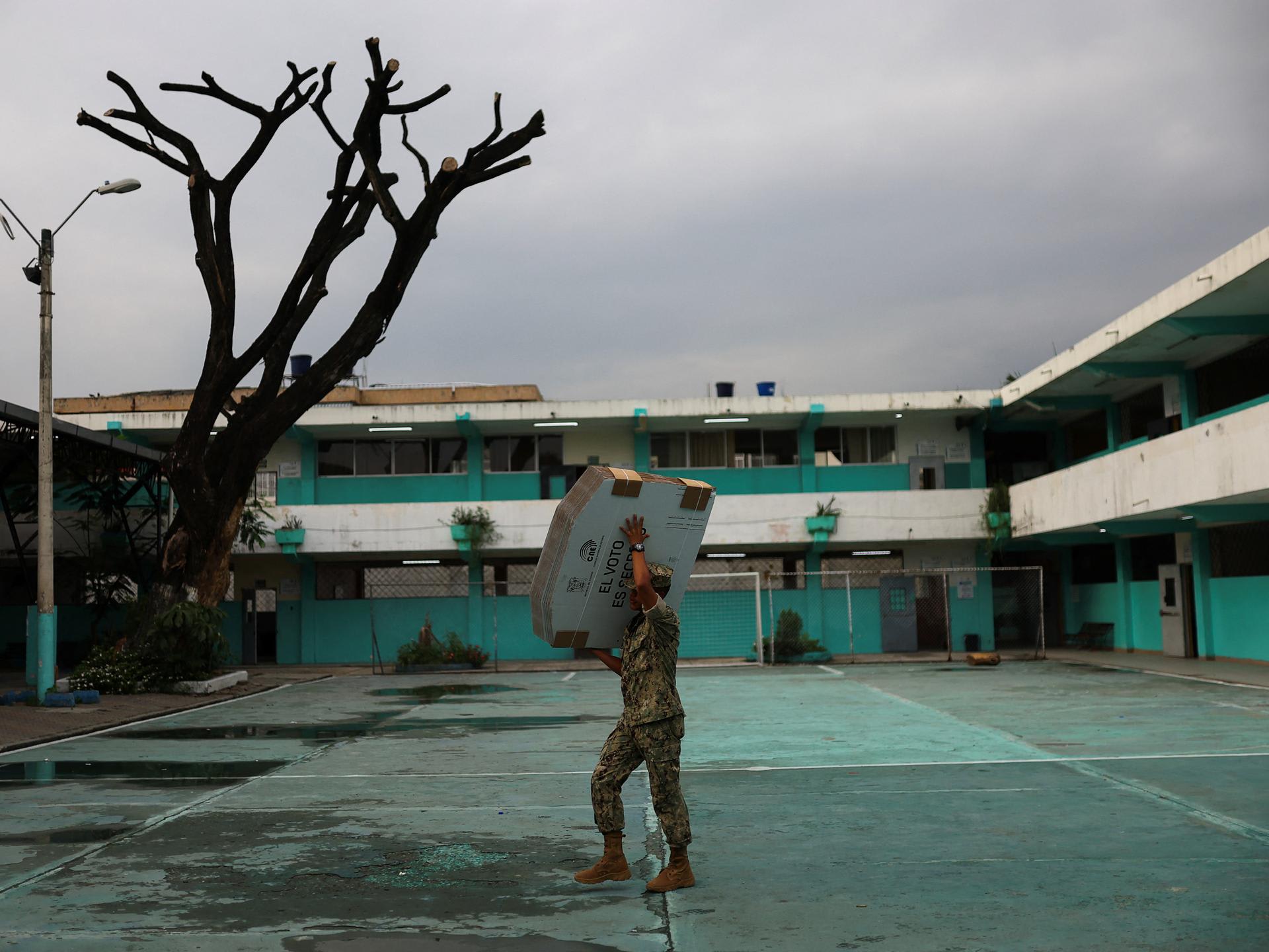 A member of the Navy carries electoral materials out to a school that is being used a polling station ahead of the presidential election, in Guayaquil, Ecuador, on February 8, 2025. REUTERS/Luisa Gonzalez