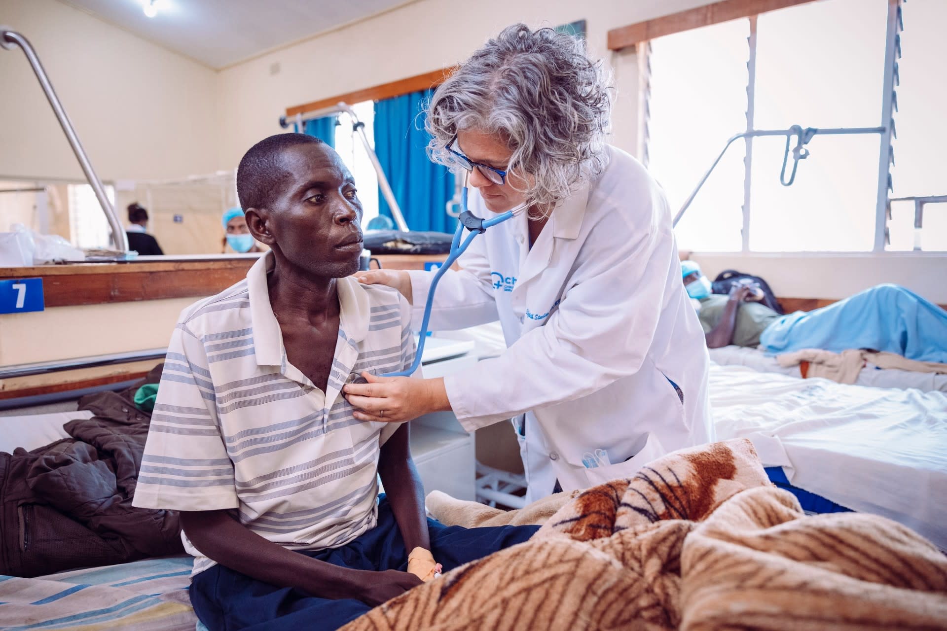 Beth Stuebing examines a patient who came in for vomiting blood.