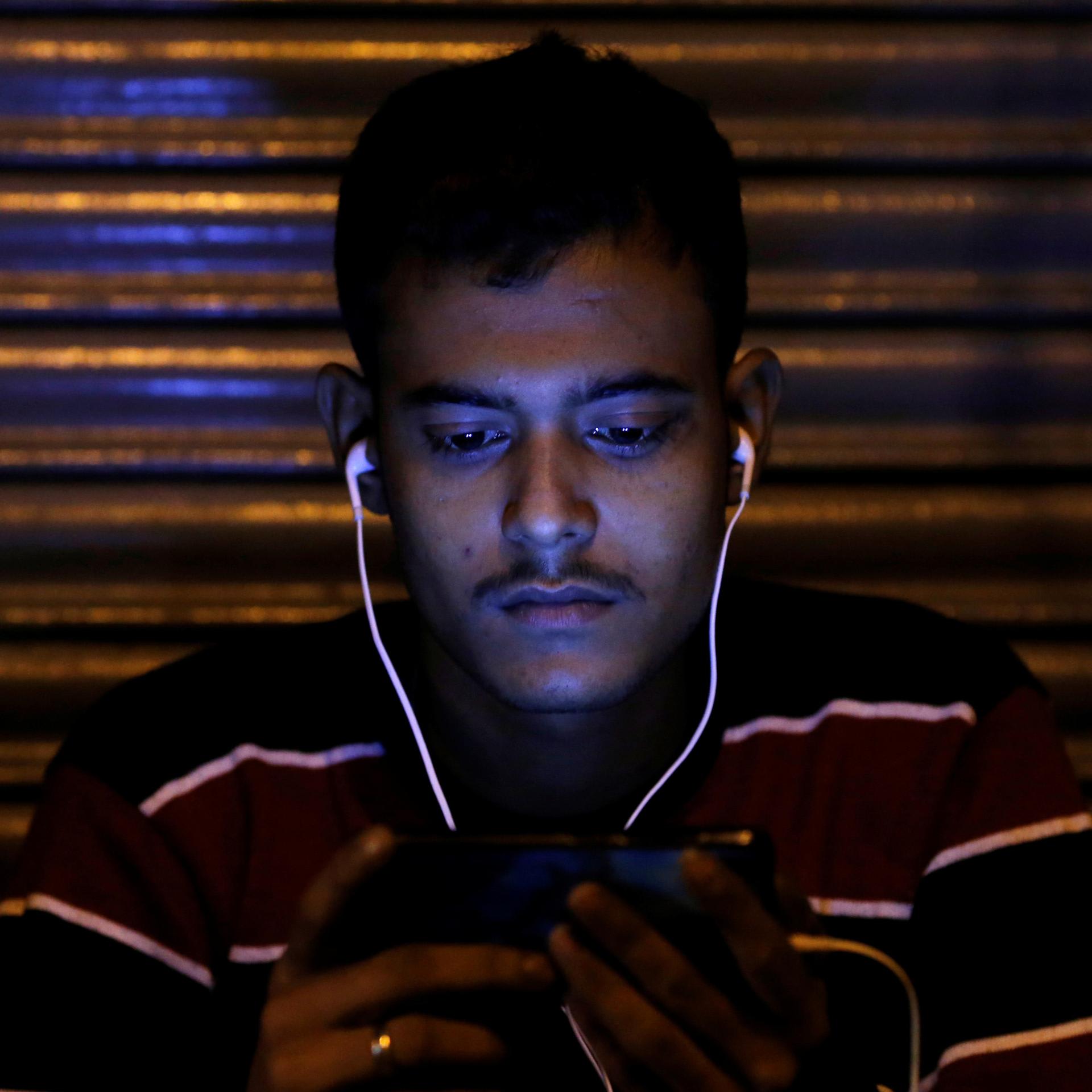 A man watches a movie on his phone, in Delhi, India, on November 16, 2016.