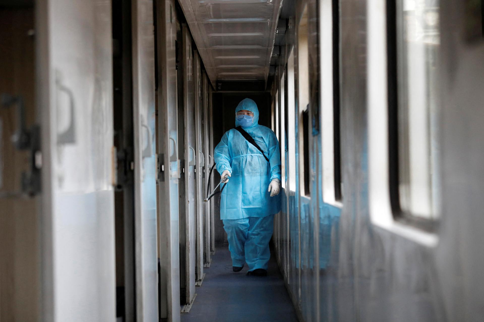 A health worker sprays disinfectants a train as a measure against the COVID-19, in Hanoi, Vietnam, on March 19, 2020.