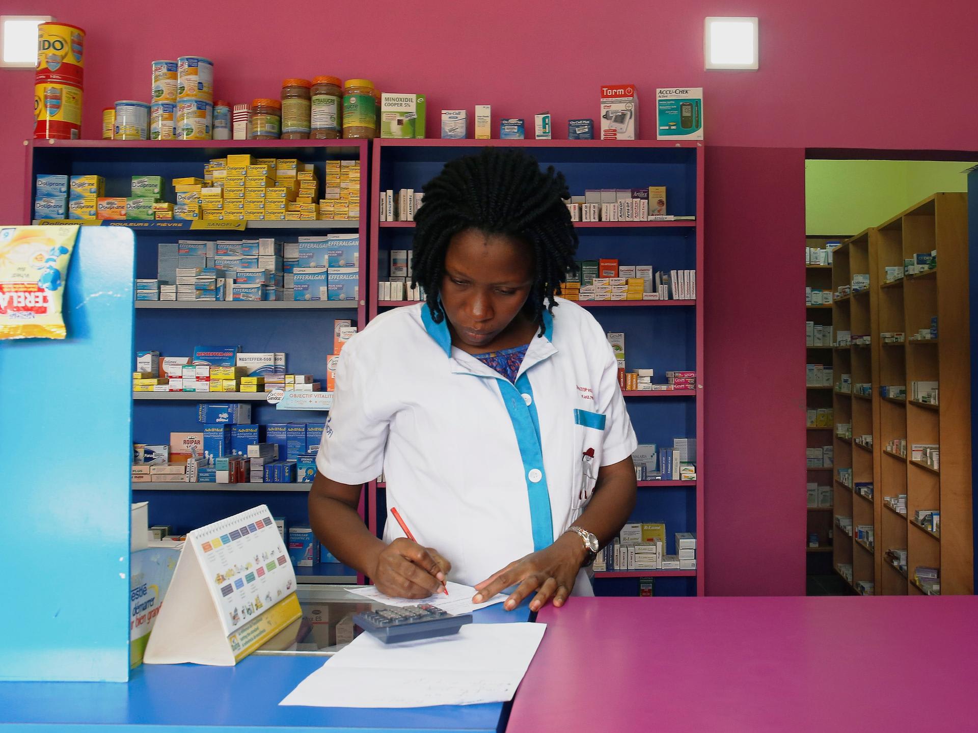 A vendor writes as she stands in a legal pharmacy, in Abidjan, Ivory Coast, on October 16, 2018. REUTERS/Luc Gnago