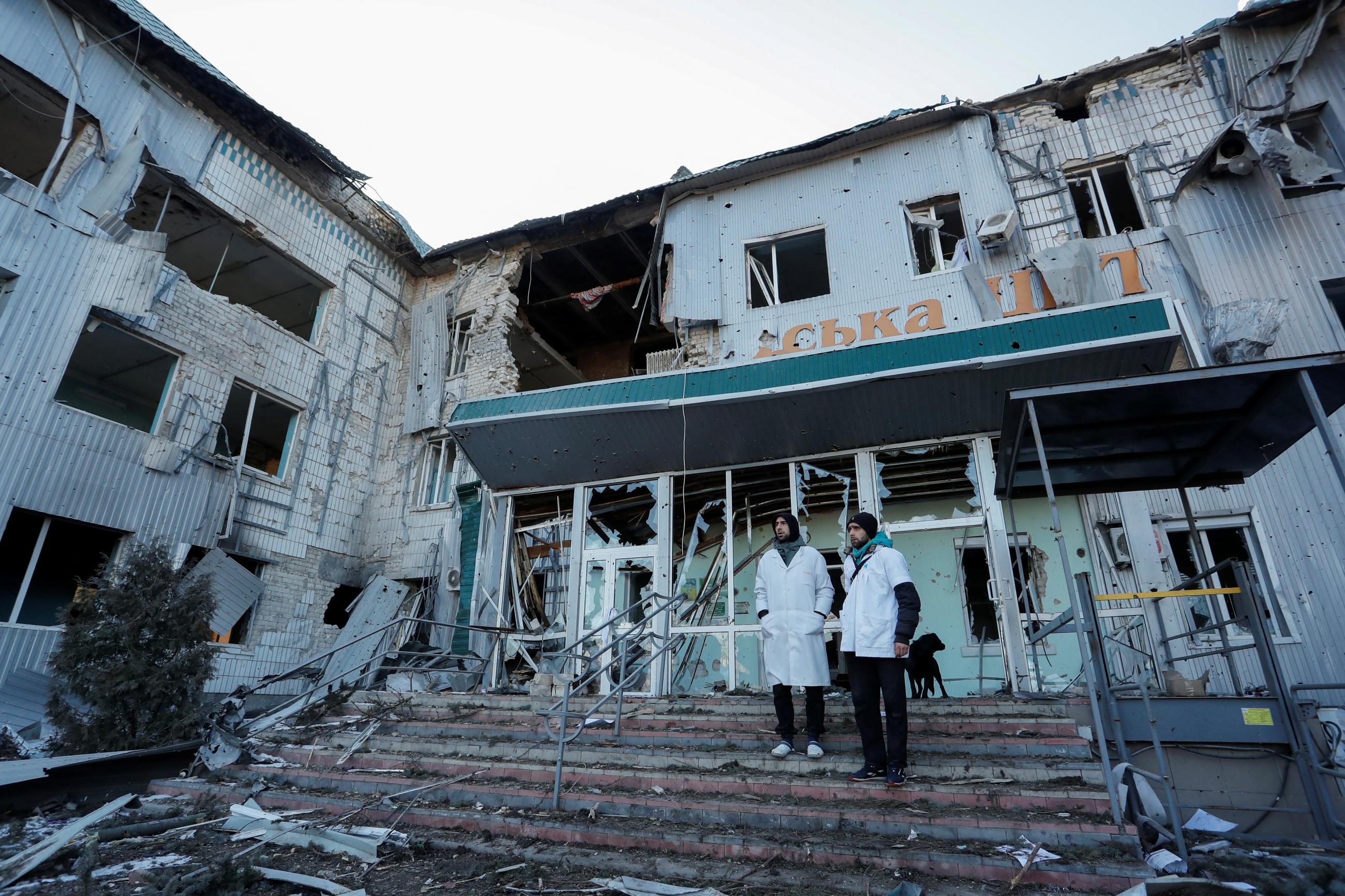 Medical workers stand outside a local hospital, which was destroyed during Russia's war in Ukraine in the Russian-occupied town of Volnovakha in the Donetsk region, Ukraine March 12, 2022.