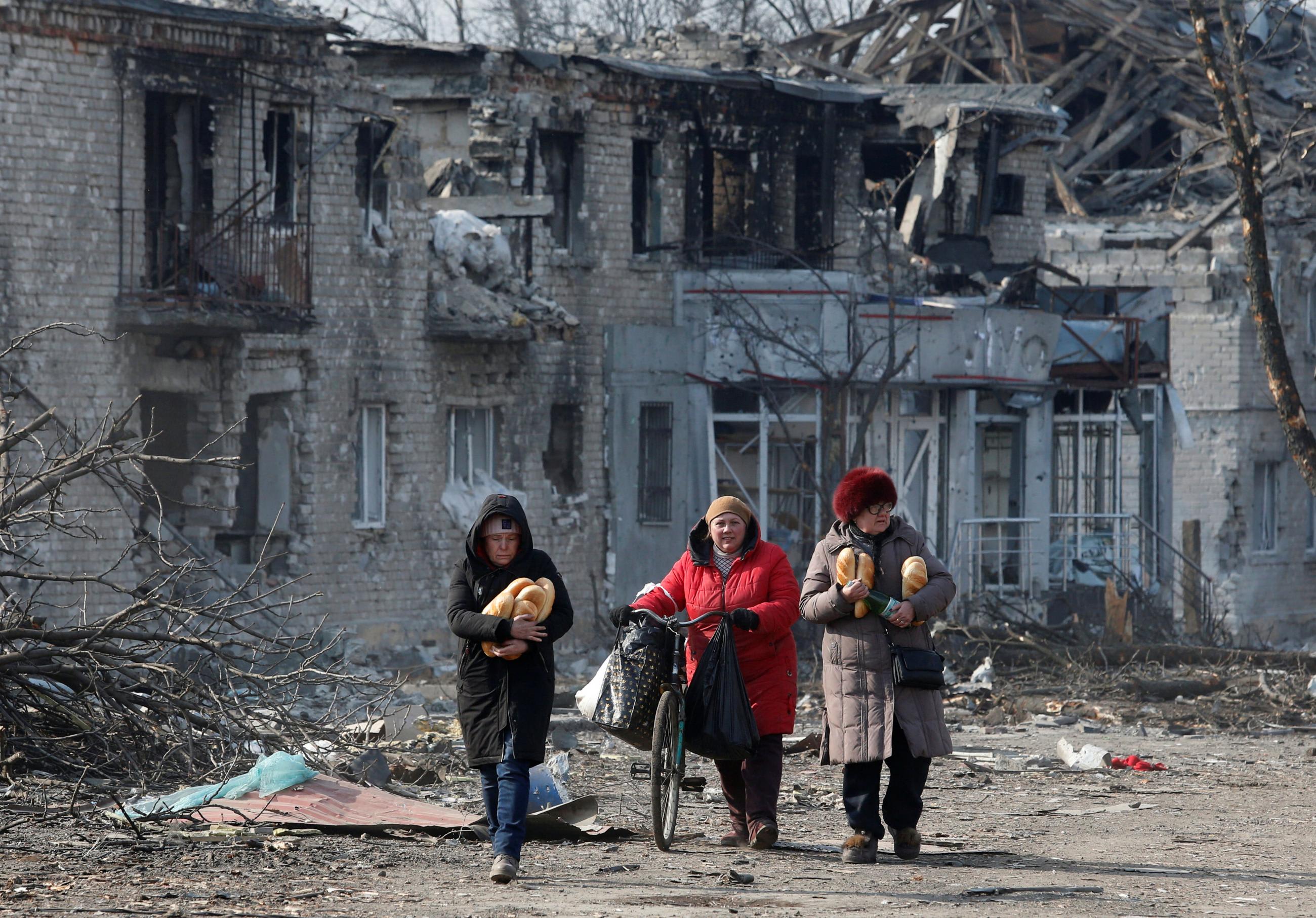 Local residents walk along a street after receiving humanitarian aid during Russia's attack in the separatist-controlled town of Volnovakha, in the Donetsk region of Ukraine, on March 15, 2022.
