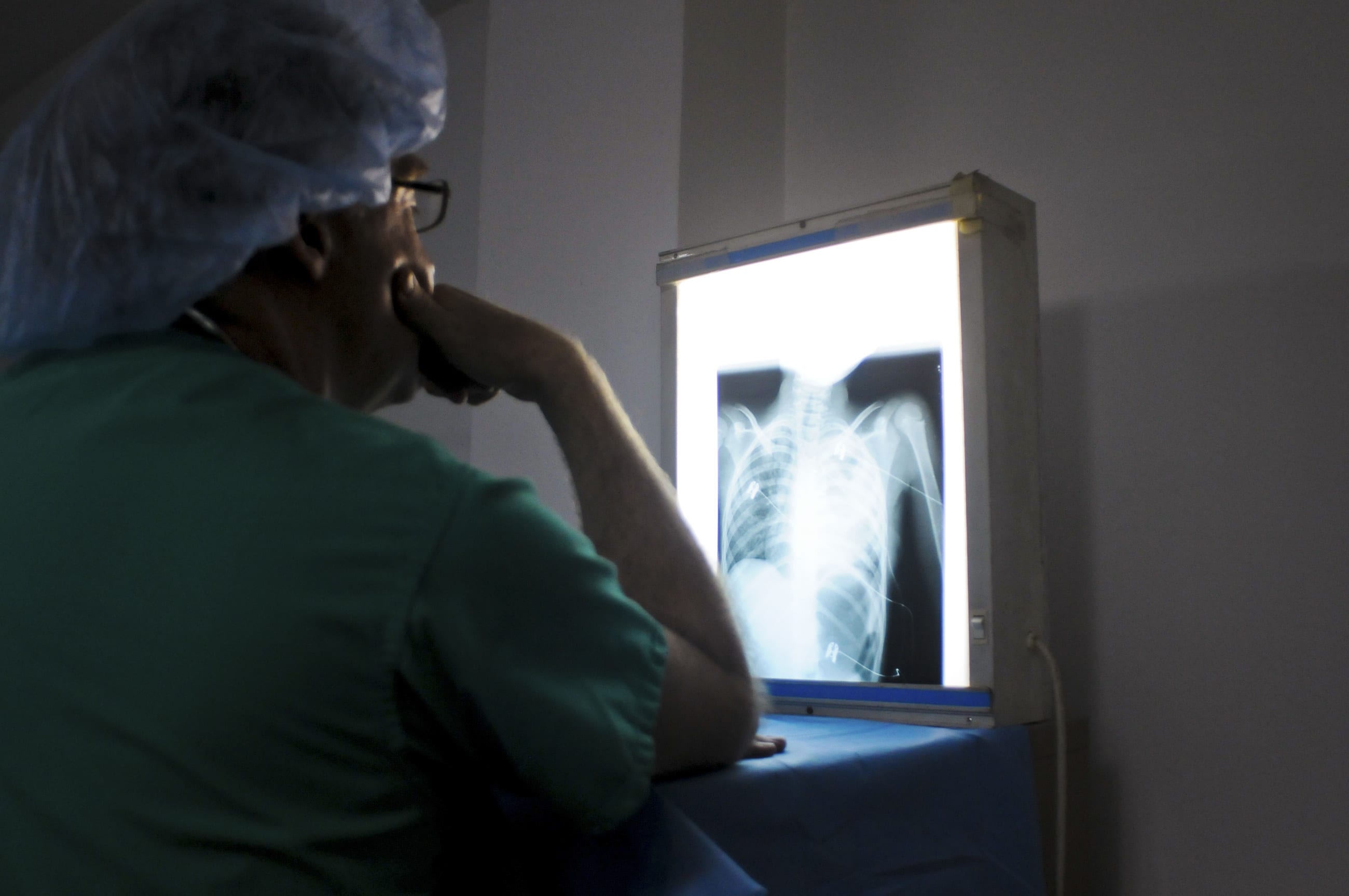 A doctor from an international cardiac mission examines the x-ray of a patient's heart, in the Degand Clinic, in Port-au-Prince, Haiti, on April 15, 2012.