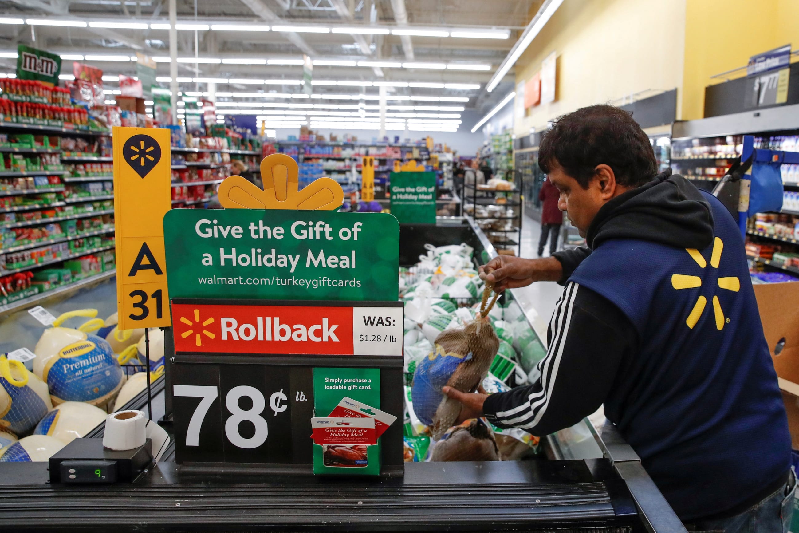 A Walmart employee puts out a frozen turkey ahead of the Thanksgiving holiday in Chicago, on November 27, 2019.