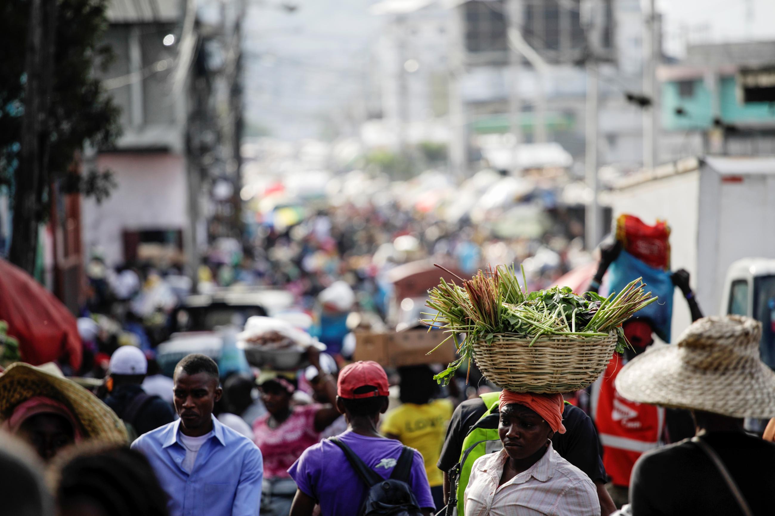 People walk along a street market in Petion Ville.