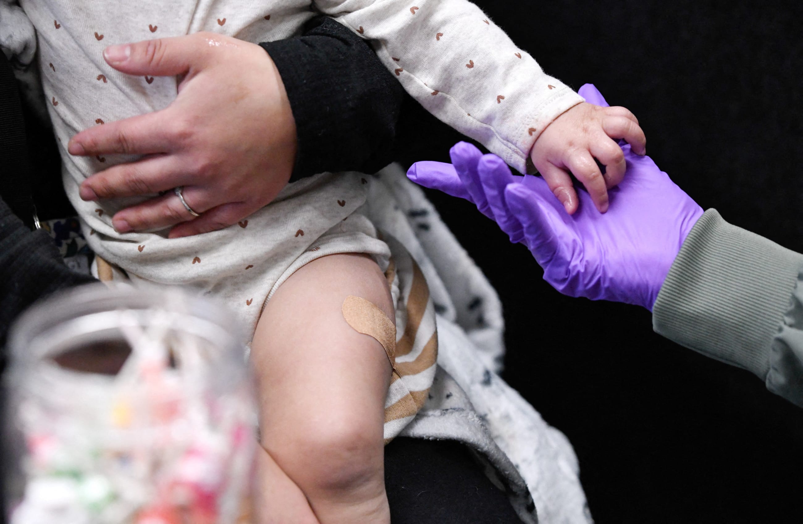 Sherry Andrews, right, holds 13-month-old Jaqi Herrera's hand after administering the first MMR vaccine dose to Herrera at the City of Lubbock Health Department in Lubbock, Texas, on February 27, 2025.