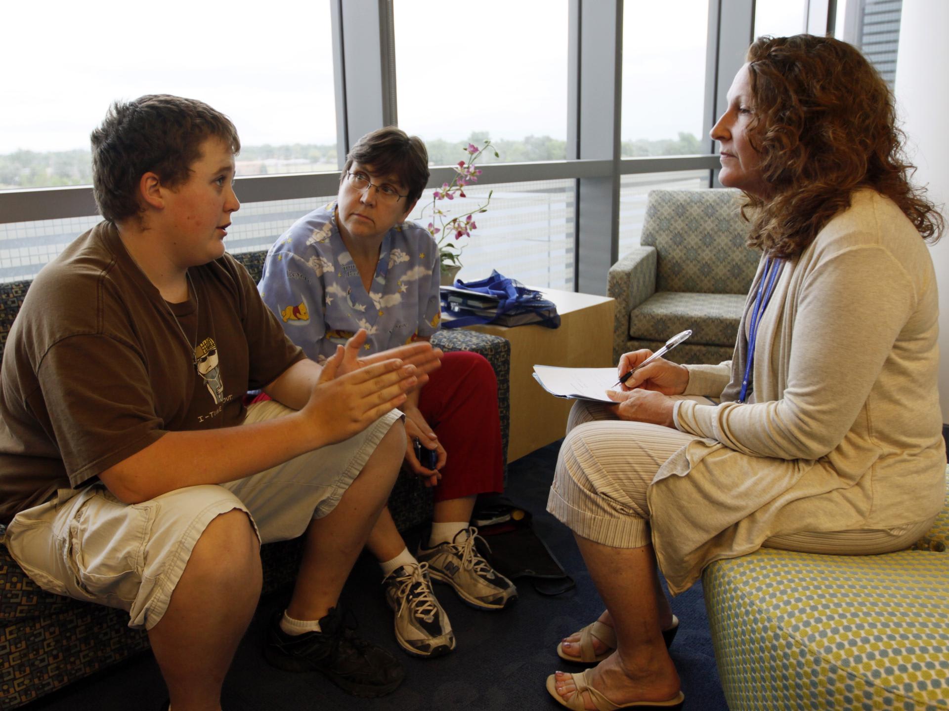 Micah Peterson, 15, and his mother talk with Marilyn Day, director of a child and teen weight management program, during a counseling session at The Children's Hospital, in Aurora, Colorado, on July 8, 2010.