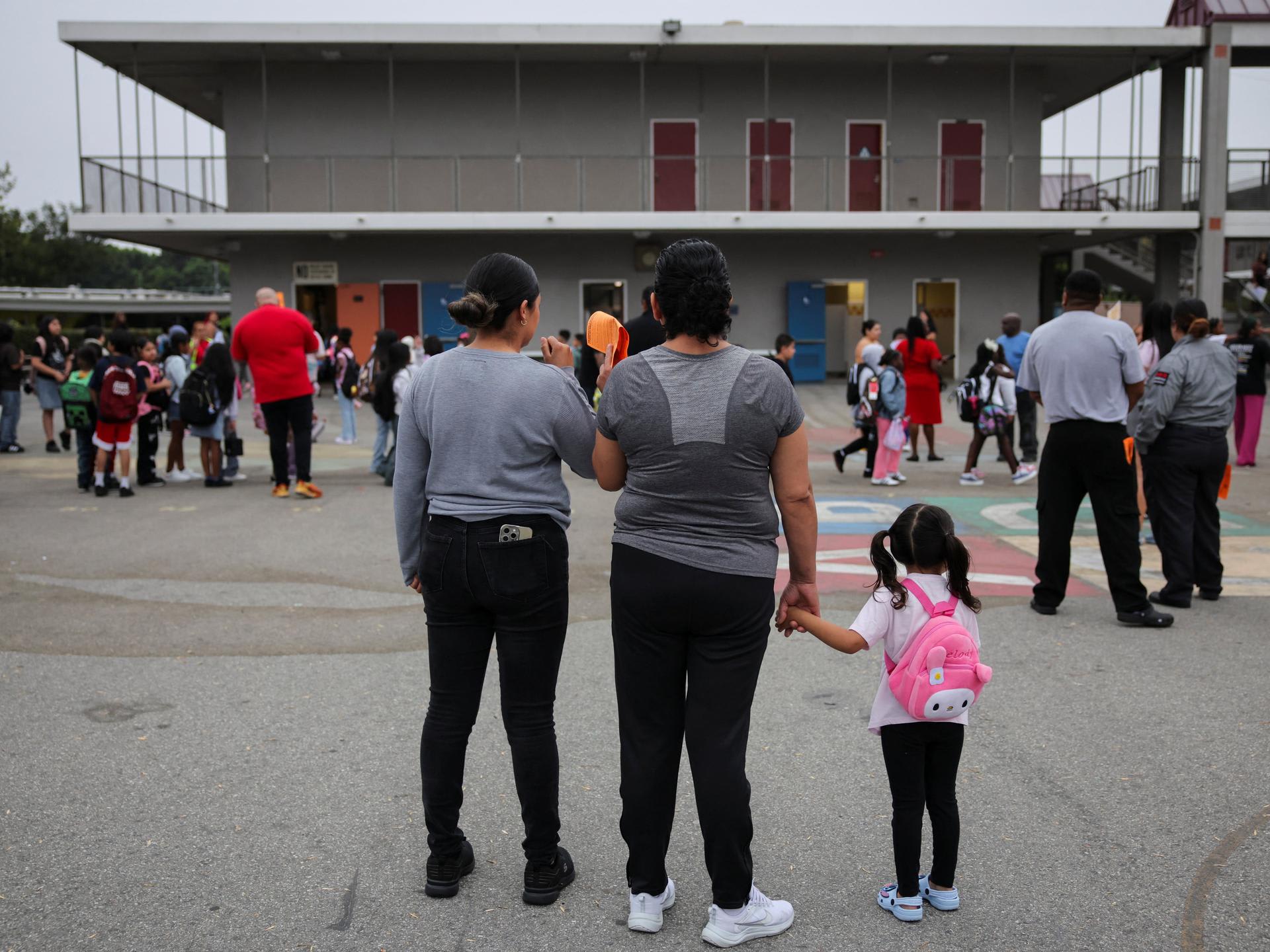 Parents and students arrive for the first day of school, as teachers and volunteers patrol for the presence of Immigration and Customs Enforcement (ICE), at the Ninety-Third Street Elementary School, in Los Angeles, California, on August 14, 2025.