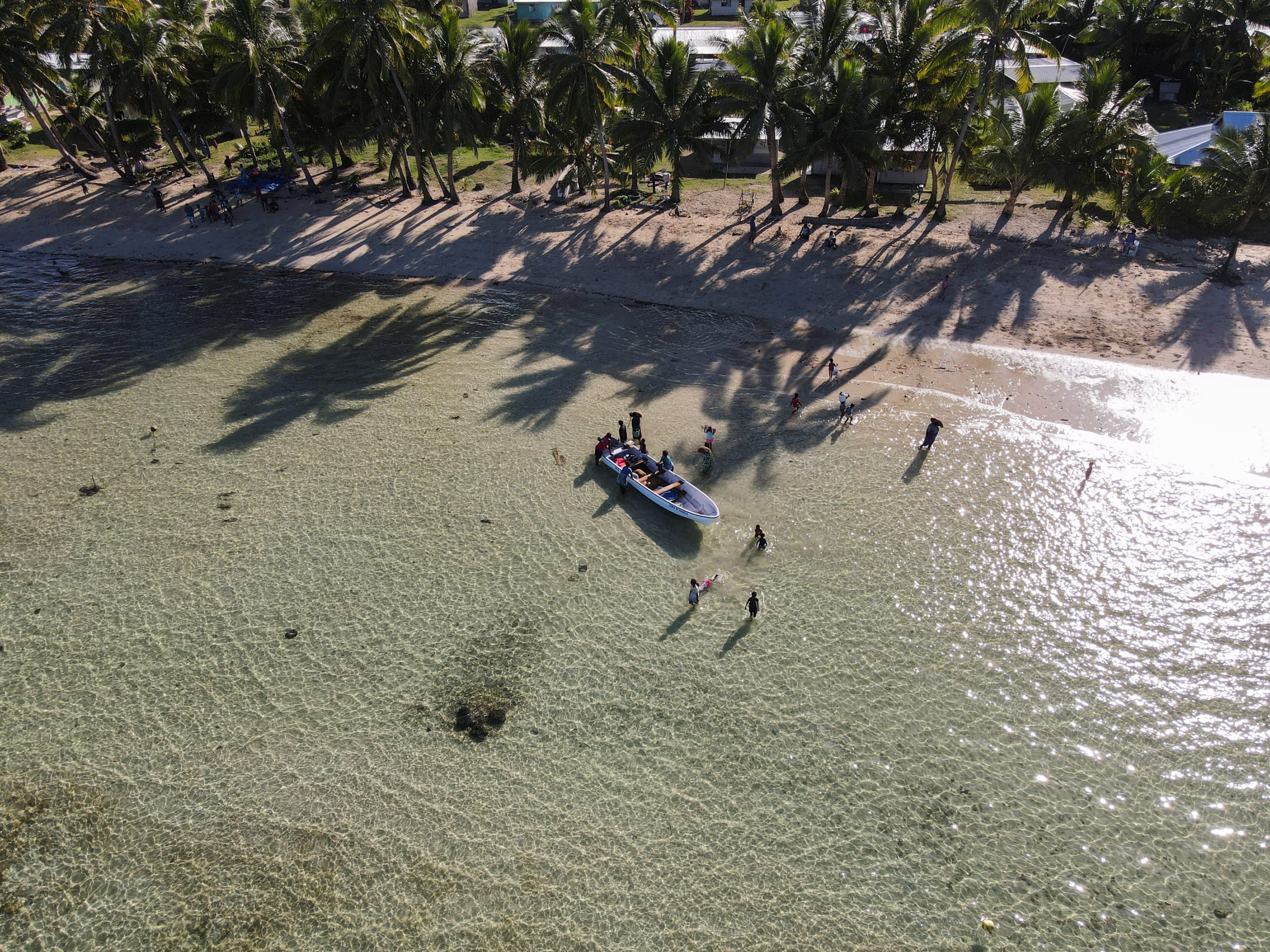 Fijian fisherwomen gather near a boat after returning from harvesting sea grapes at sea, near Namuaimada village, Viti Levu, Fiji, on July 14, 2022.