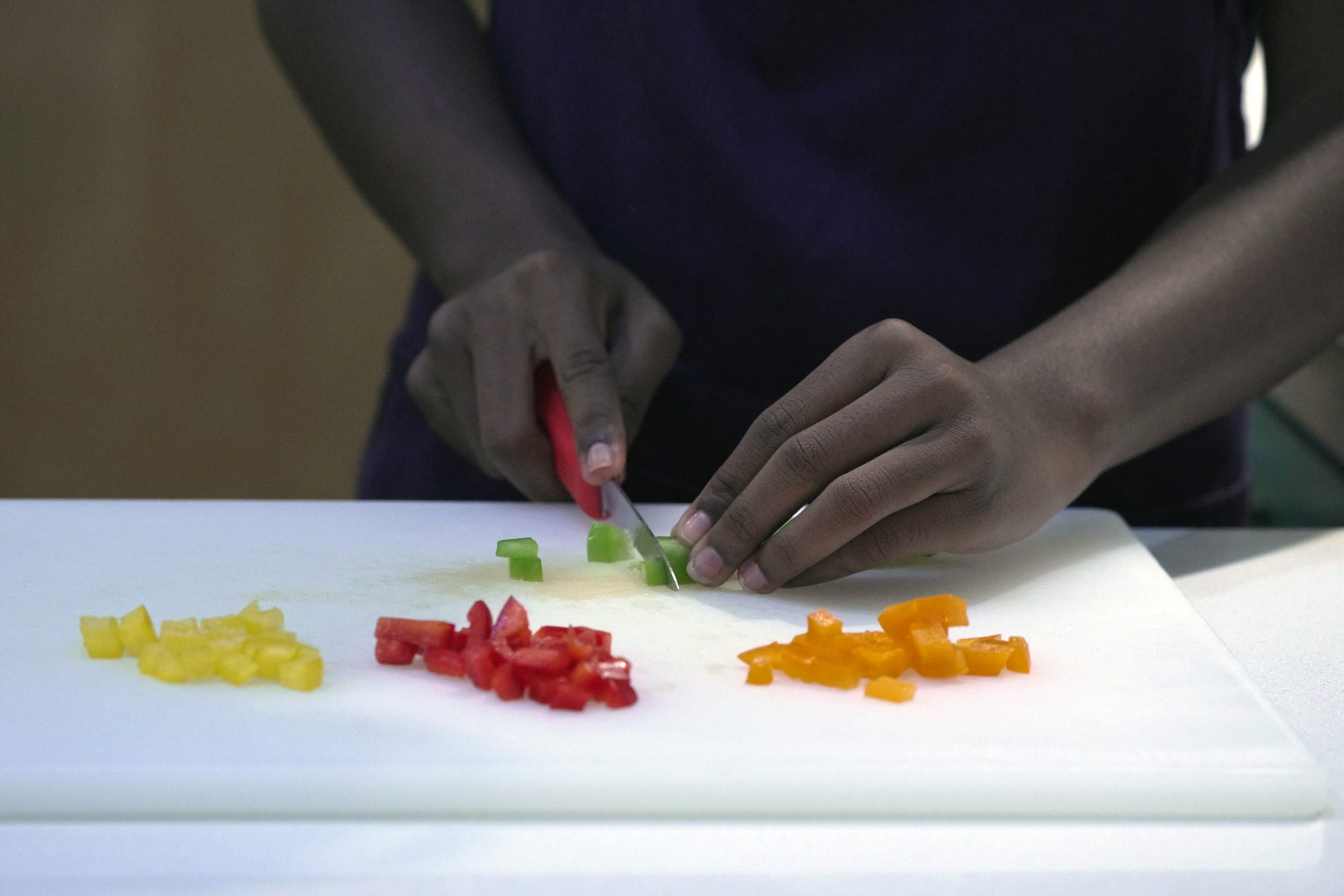 An attendee cuts ingredients at a cooking class run by Church Health and designed to help students learn how to make healthy food on a budget, in Memphis, Tennessee, on September 09, 2023.